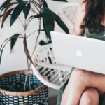 woman sitting and using MacBook